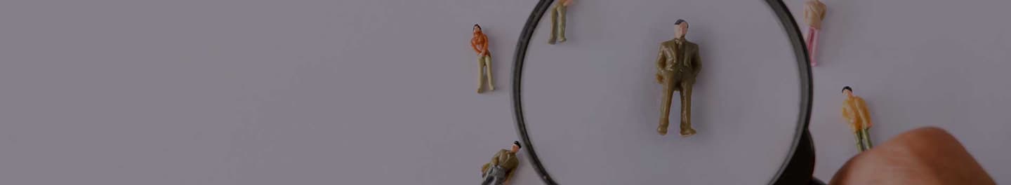 Magnifying glass held over a individual.