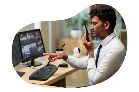 Security guard checking on activity they see on a monitor. Security guard checking on activity they see on a monitor.