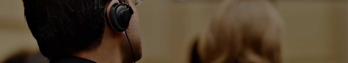 Man with an earpiece in a large room.