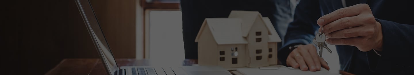 Laptop, model home, and keys.