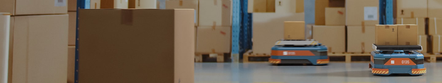 Cardboard boxes being moved around by robots in a warehouse.