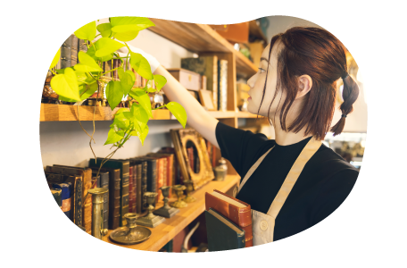 An employee arranging books in an antique shop.