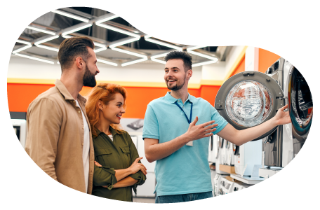 An employee at an appliance store shows off a dryer to customers.