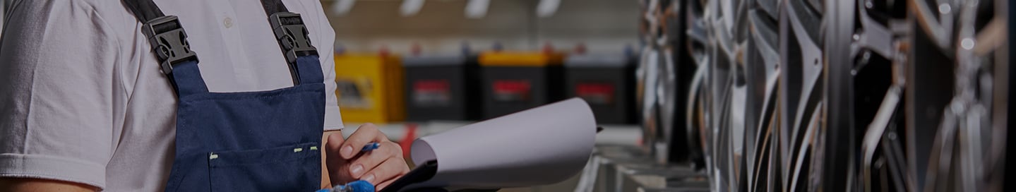 An employee at an auto parts store checks a rack of wheels.