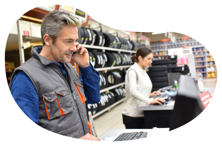 Auto supply store employees working on computers at a store counter.