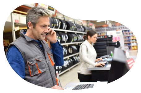 Auto supply store employees working on computers at a store counter. Auto supply store employees working on computers at a store counter.
