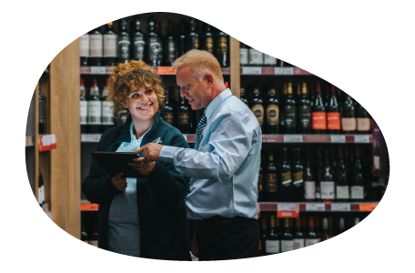 Liquor store salesman showing inventory to a client. Liquor store salesman showing inventory to a client.