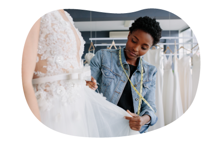 Bridal shop employee measuring a client wearing a wedding dress. Bridal shop employee measuring a client wearing a wedding dress.