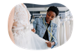 Bridal shop employee measuring a client wearing a wedding dress.