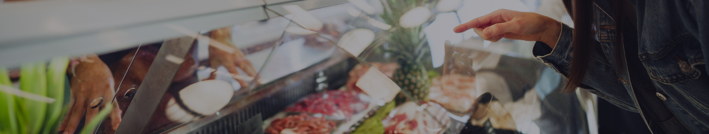 A customer looks at the selection in a butcher's display case.
