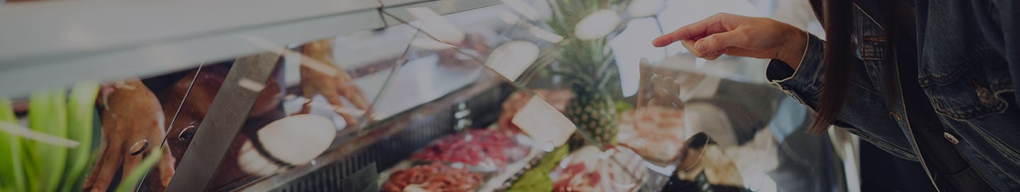 A customer looks at the selection in a butcher's display case. A customer looks at the selection in a butcher's display case.