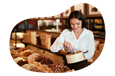 Candy store employee stocking front case in a shop.