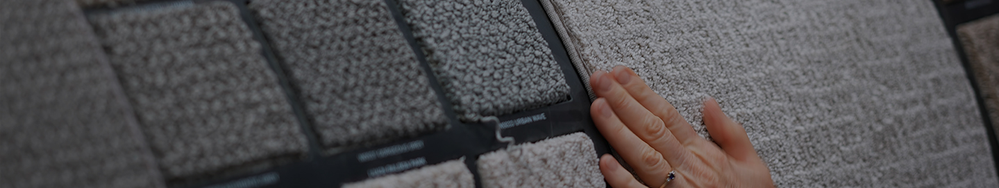 A customer examines swatches of carpet at a store.