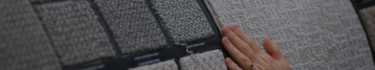 A customer examines swatches of carpet at a store. A customer examines swatches of carpet at a store.