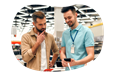 A cell phone store owner showing new features on a smartphone to a customer