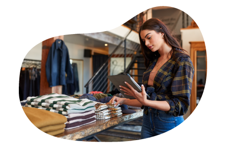Clothing store employee taking inventory of shirts on a table. Clothing store employee taking inventory of shirts on a table.