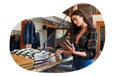 Clothing store employee taking inventory of shirts on a table.