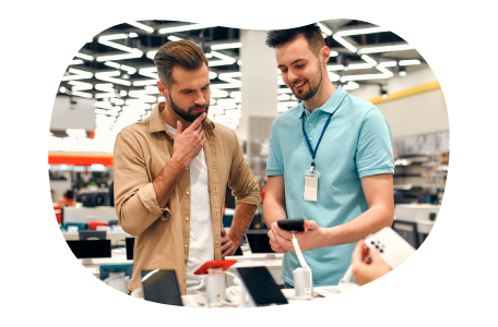 Electronics store employee showing smartphones on display to a customer.