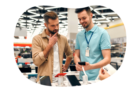 Electronics store employee showing smartphones on display to a customer. Electronics store employee showing smartphones on display to a customer.