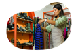 Thrift store employee hanging up new donations on a rack.