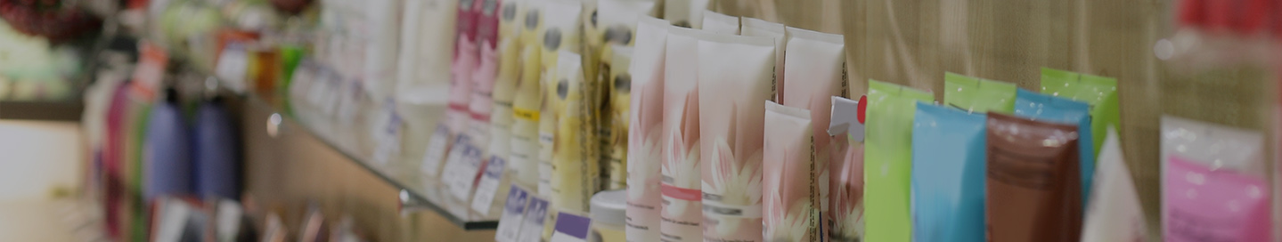Colorful tubes of skin care products on a glass shelf.