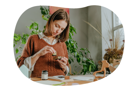 An Etsy seller stamps a handmade craft. An Etsy seller stamps a handmade craft.