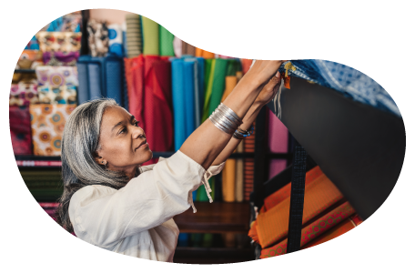 The owner of a fabric store examines a bolt of fabric. The owner of a fabric store examines a bolt of fabric.