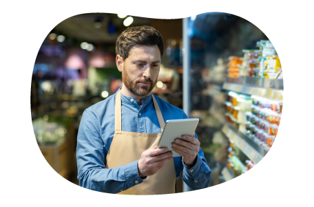 The owner of a general store checks a list of products on a tablet. The owner of a general store checks a list of products on a tablet.