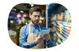 The owner of a general store checks a list of products on a tablet.
