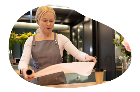 An employee at a gift shop prepares to wrap a gift.