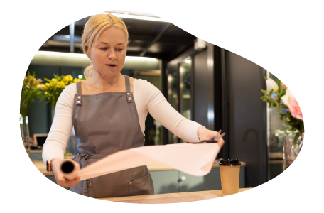 An employee at a gift shop prepares to wrap a gift. An employee at a gift shop prepares to wrap a gift.