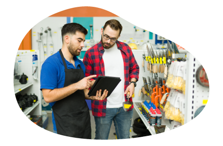 An employee helps a customer find the right item at a hardware store.