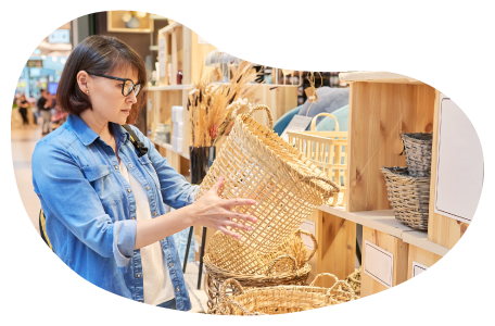 A customer examines a basket at a home decor shop. A customer examines a basket at a home decor shop.