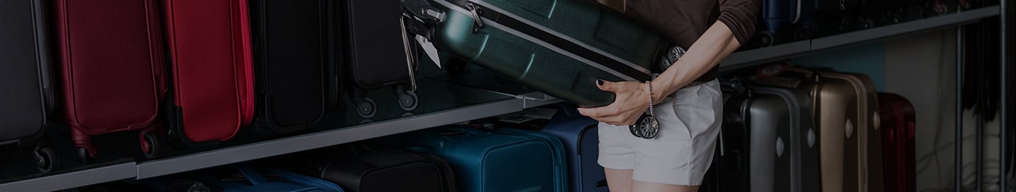 A customer examines a piece of luggage in a store. A customer examines a piece of luggage in a store.