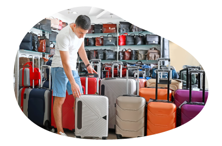 A customer looks over a selection of rolling luggage. A customer looks over a selection of rolling luggage.