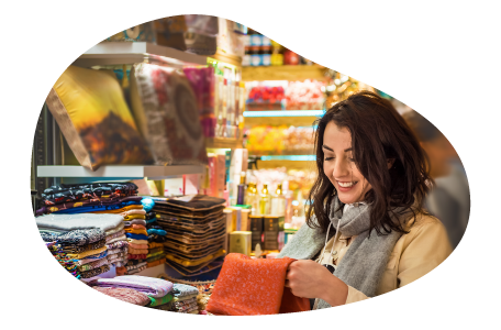 A shopper examines a colorful scarf in a mall kiosk. A shopper examines a colorful scarf in a mall kiosk.