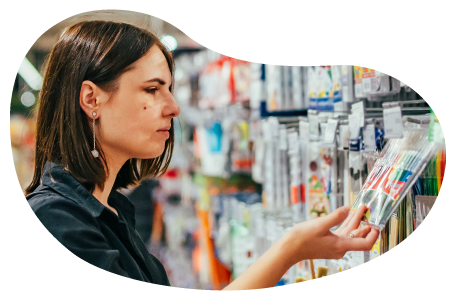 A customer examines a package of colorful markers at an office supply store.