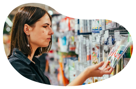 A customer examines a package of colorful markers at an office supply store. A customer examines a package of colorful markers at an office supply store.