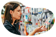A customer examines a package of colorful markers at an office supply store.