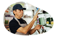 A business owner examines a can of paint in their paint and wallpaper store.