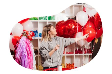 The owner of a party supply store arranging red and white balloons. The owner of a party supply store arranging red and white balloons.