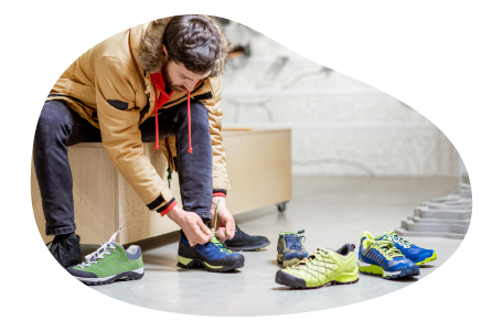 A customer tries on a pair of sneakers in a shoe store.