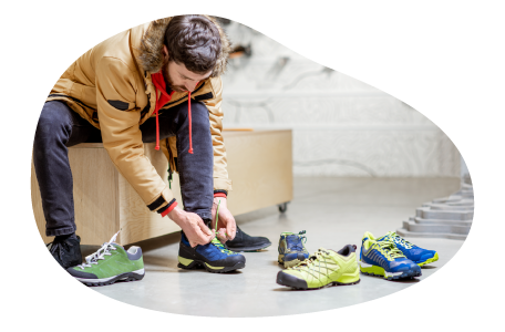 A customer tries on a pair of sneakers in a shoe store. A customer tries on a pair of sneakers in a shoe store.