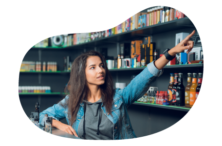 Tobacco shop employee helping a customer find a product on a shelf.