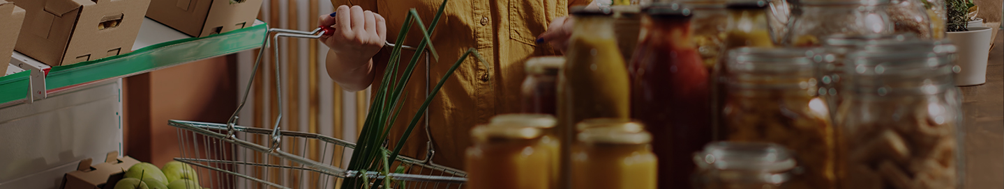 A customer shops with a handbasket in a specialty food store.