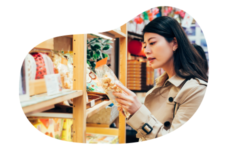 A shopper picks up a bag of popcorn in a specialty food store. A shopper picks up a bag of popcorn in a specialty food store.
