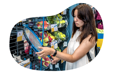 A customer examines a tennis racket at a sporting goods store.