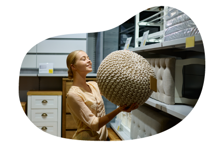 A Wayfair seller looks at a pouf ottoman in their warehouse.