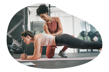 Athletic trainer coaching a client in a gym.