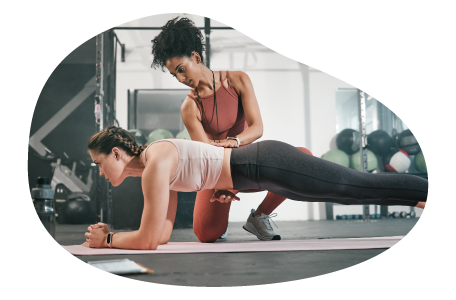 Athletic trainer coaching a client in a gym. Athletic trainer coaching a client in a gym.